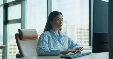 Kendini işine adamış profesyonel bir kadın, parlak ve modern bir ofiste, şık bir masadaki işine odaklanmış, yaratıcılığını ilham verici. Yüksek kalite 4k görüntü