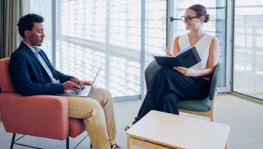 Bir erkek ve bir kadın şık ve modern bir ofis ortamında profesyonel bir tartışmaya girişirler.