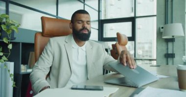 Çağdaş bir ofis ortamında, bir iş adamı stresi etkili bir şekilde yönetirken deneyimlerini derin bir şekilde yansıtır.