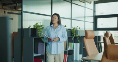 Zarif bir ofiste kendine güvenen bir kadın, bir sonraki kariyer adımlarını ve fırsatlarını düşünen bir tablet taşıyor. Yüksek kalite 4k görüntü