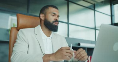 Verimliliği ve işbirliğini artıran şık bir ofiste gelişmiş teknolojiyle dokümanları inceleyen bir işadamı.