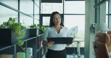 Adanmış bir profesyonel, bir ofiste önemli belgeleri inceler ve analiz eder. Detayların standartları karşılamasını sağlar. Yüksek kalite 4k görüntü