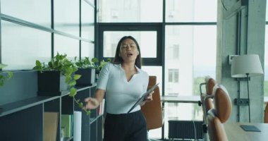 Dinamik ve tutkulu bir profesyonel, canlı ve modern ofis ortamında coşkularını sergiliyor. Yüksek kalite 4k görüntü