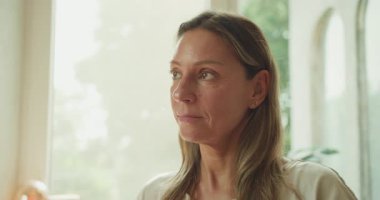 Huzurlu bir kadın, yumuşak, sıcak doğal ışığı derinden yansıtır. Hayatının özünü düşünür.