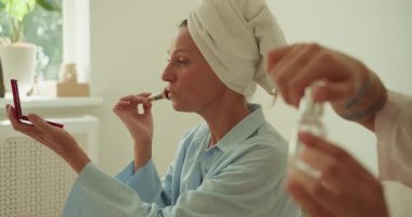 Bir kadın huzurlu ve huzurlu bir ortamda zarif bir şekilde makyaj yapıyor, sakin bir güzellik gösterisi sergiliyor.