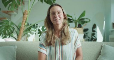 Neşeli bir kadın, yemyeşil yemyeşil bir koltukta, ışıl ışıl bir atmosfer ve ışıl ışıl bir hava içinde, rahat bir koltukta oturur.