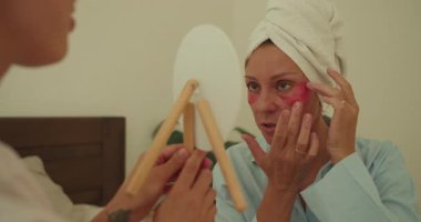 Sakinleştirici bir ortamda, bir kadın kendini iyileştirme ve sağlığın değerini vurgulayarak, gençleştirici bir yüz ifadesinden zevk alır.