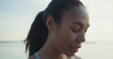 Sakin bir sporcu, su kenarında dinlendirici müziğin keyfini çıkarırken, doğada farkındalığı ve zindeliği tamamen kucaklıyor.