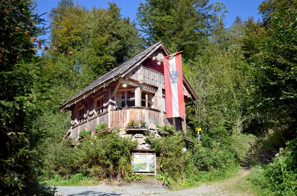 位于施蒂里亚州的一座名叫Strutz Mill的老水磨坊建造的带有木制屋顶和奥地利国旗的木屋 在争夺奥地利最美丽 最有趣的地方和文化财富的比赛中也是获胜者 — 图库照片