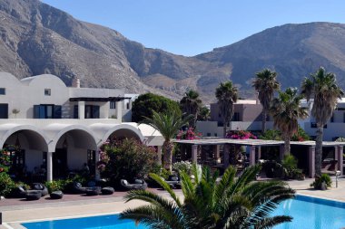 Santorini, Yunanistan - 28 Haziran 2022: Bilinmeyen tatilciler Perissa köyünde havuzlu zarif otel kompleksinin keyfini çıkarıyorlar