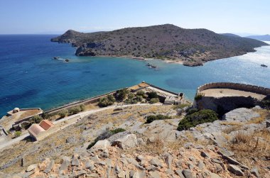 Greece, Crete, buildings built of stone in old Venetian Fortress Spinalonga, until 1957 used as a leper station, now a popular tourist destination, view of the uninhabited Kalydon peninsula 