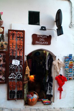 Ostuni, Italy - June 13, 2007: Tiny shop for clothes, sandals and souvenirs in the town in Pugliy