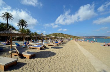 Vai, Yunanistan - 12 Ekim 2022: Adanın en kuzeydoğusunda kumlu plajları olan pek çok palmiye ağacı nedeniyle, Vai plajında dinlenen kimliği belirsiz insanlar popüler fakat korunması zor bir bölge
