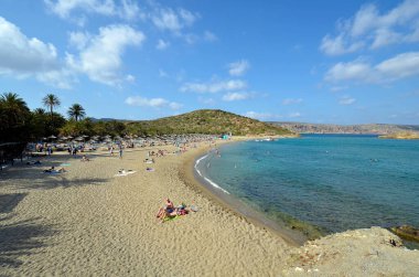 Vai, Yunanistan - 12 Ekim 2022: Adanın en kuzeydoğusunda kumlu plajları olan pek çok palmiye ağacı nedeniyle, Vai plajında dinlenen kimliği belirsiz insanlar popüler fakat korunması zor bir bölge