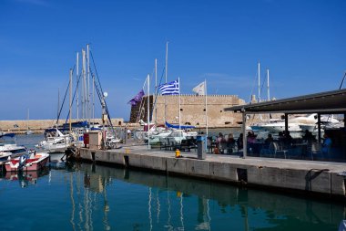 Iraklio, Yunanistan - 14 Ekim 2022: Girit Adası 'nın başkenti, Venedik kalesi Koules ve liman restoranındaki insanları barındıran yatlar ve balıkçı tekneleri için küçük bir liman