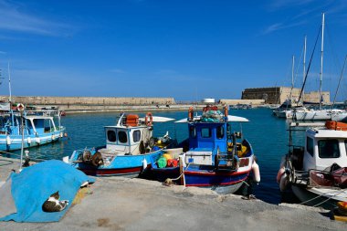Iraklio, Yunanistan - 14 Ekim 2022: Girit Adası 'nın başkenti, Venedik Kalesi Koules ile küçük yat ve balıkçı tekneleri limanını gezerek kimliği belirsiz insanlar