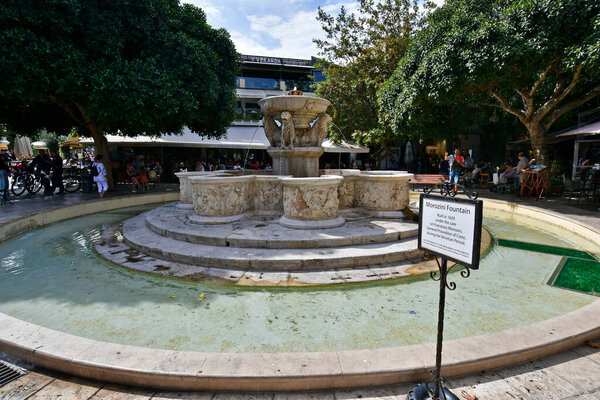 Iraklio, Greece - October 14, 2022: The capital of Crete Island, unidentified people at Morozini fountain - a Venetian building and landmark from 17th century
