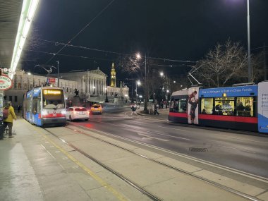Viyana, Avusturya - 20 Mart 2023: Avusturya parlamentosu ile tramvay ve istasyon, arka plandaki belediye kulesi Viyana Halkası boyunca en heybetli binalardan biri