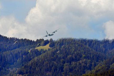 Zeltweg, Avusturya - 03 Eylül 2022: Styria 'da Airpower 22 adlı halka açık hava gösterisi, uçuş gösterisi - iki Eurofighter Typhoon jet savaş uçağı bir C-130 Herkül taşıyıcısını takip ediyor