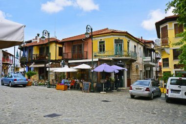 Arnea, Yunanistan - 10 Haziran 2023: Halkidiki 'deki Aarnea dağ köyünün ana meydanındaki bilinmeyen kişiler, arabalar ve restoranlar