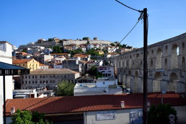 Kavala, Yunanistan - 13 Haziran 2023: Bizans 16. yüzyıldan kalma su kemeri Kamares ve tepede güçlendirilmiş duvarlı ortaçağ kalesi, Ege Denizi üzerindeki kentin simgeleri