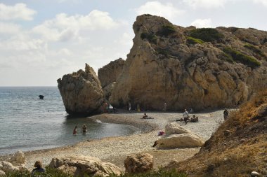 Episkopi, Kıbrıs - 27 Eylül 2023: Efsaneye göre, Tanrıça Afrodit 'in doğduğu yer olan Rock of Afrodit plajında kimliği belirsiz insanlar