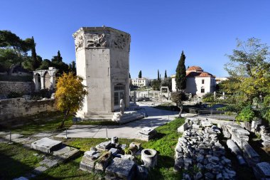 Atina, Yunanistan - 19 Aralık 2023: Plaka bölgesindeki antik Roma Agora 'da Rüzgâr Kulesi ve Fethije Camii ile yıkıntılar