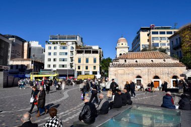 Atina, Yunanistan - 19 Aralık 2023: Monastiraki meydanında Panagia Pantanasa the Atinalı olarak bilinen küçük Bizans kilisesi ile kimliği belirsiz kişiler,