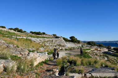 Lavrio, Greece - December 19, 2023: Unknown tourists at Lavreotiki Geopark and ancient mining center - silver, copper and lead used to be found here - there are also the remains of the ancient Theater of Thorikos clipart