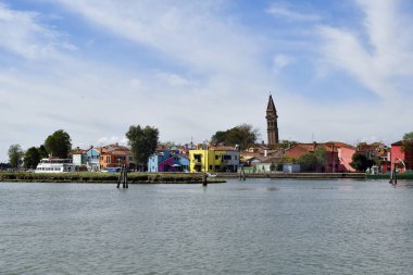 Burano, İtalya - 17 Nisan 2024: Venedik yakınlarındaki adanın renkli evleri ve 16. yüzyılda inşa edilen Chiesa Parrocchiale di San Martino Vescovo kilisesinin eğimli kulesi