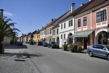 Pas, Avusturya - 23 Mart 2024: Burgenland 'daki UNESCO dünya mirası sahasındaki renkli ve pitoresk evleriyle Neusiedl Gölü' ndeki sözde leylek kasabasının ana caddesi
