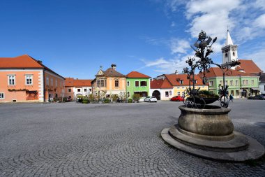 Pas, Avusturya - 23 Mart 2024: Burgenland 'daki UNESCO dünya mirası sahasının çatılarında bulunan güzel evleri ve leylek yuvalarıyla Neusiedl Gölü' ndeki sözde leylek kasabasında Eagles Çeşmesi ile döşenmiş belediye meydanı.