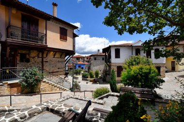 Arnea, Yunanistan - 15 Haziran 2024: Halkidiki dağlarındaki pitoresk köyde güzel renkli evler ve asfalt caddeler