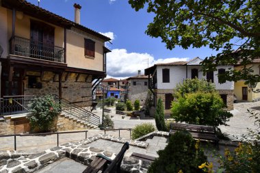 Arnea, Greece - June 15, 2024: Beautiful colorful houses and paved street in the picturesque village in the mountains of Halkidiki clipart