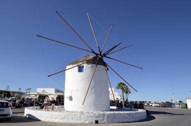 Parikia, Yunanistan - 17 Eylül 2024: Paros adasındaki Parikia limanındaki eski yel değirmeninin etrafındaki kimliği belirsiz insanlar