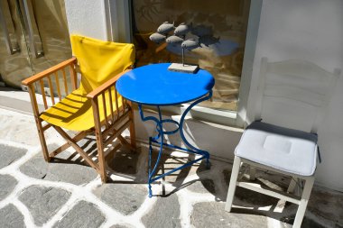 Paros, Yunanistan - 17 Eylül 2024: Eski Parakia kentinin yaya bölgesinde balık heykeliyle renkli oturma