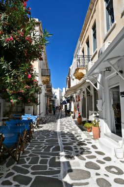 Paros, Yunanistan - 17 Eylül 2024: Bilinmeyen kişiler, Parikia 'nın eski kenti Parikia' da çeşitli dükkanları ve restoranları olan dar sokaklarda geziniyor