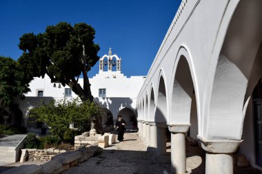 Paros Adası, Yunanistan - 17 Eylül 2024: Kiklad 'ın Paros adasındaki tarihi Bizans kilise kompleksi Panagia Ekatontapyliani' nin avlusunda kimliği belirsiz bir rahip