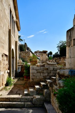Atina, Yunanistan - Plaka 'daki eski binalar ve merdivenler ve arka plandaki Roma Agora' sına giriş kapısı Athena Archegetis