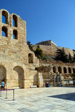 Atina, Yunanistan - 25 Eylül 2024: Herodium 'un arkasında tanımlanamayan turistler - Herodes Atticus Odeumu ve yukarıda Akropolis' in Partheneon 'u