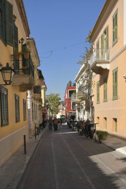 Atina, Yunanistan - 25 Eylül 2024: Dar bir sokakta binaları olan kimliği belirsiz kişiler