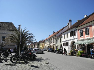 Pas, Avusturya - 20 Nisan 2025: Tanımlanamayan kişiler, Leylekler Şehri olarak da bilinen Neusiedl Gölü 'ndeki Unesco bölgesini, ana cadde boyunca farklı pitoresk binalar ve çatılardaki leylek yuvalarıyla ziyaret ediyorlar.