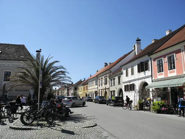 Pas, Avusturya - 20 Nisan 2025: Tanımlanamayan kişiler, Leylekler Şehri olarak da bilinen Neusiedl Gölü 'ndeki Unesco bölgesini, ana cadde boyunca farklı pitoresk binalar ve çatılardaki leylek yuvalarıyla ziyaret ediyorlar.