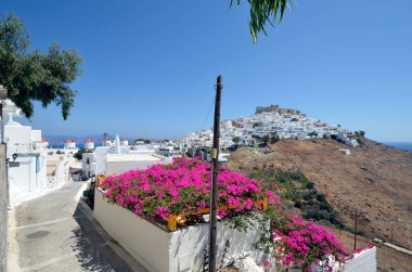 Astypalea, Yunanistan - 4 Eylül 2025: Ege Denizi 'ndeki adada eski şatosu ve yel değirmenleriyle çarpıcı beyaz Chora kasabasını görmek