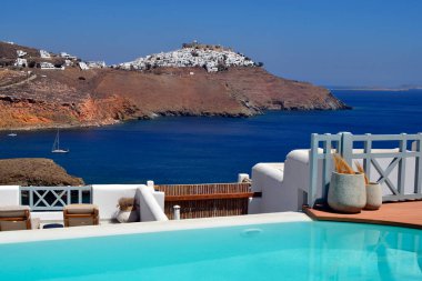 Astypalea, Yunanistan - Eylül 04, 2025: Ege Denizi 'ndeki adada bulunan eski kale ve kiliseye sahip beyaz Chora kasabasına küçük bir havuzu olan bir terastan bakmak