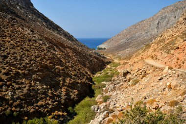 Astypalea, Yunanistan - 06 Eylül 2025: Ege Denizi 'ndeki adanın en güzel plajlarından biri olan Vatses plajına giden çakıllı yol