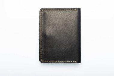 Beyaz arka plandaki bir düğmede siyah deri cüzdan, kurt izi. Üst görünüm