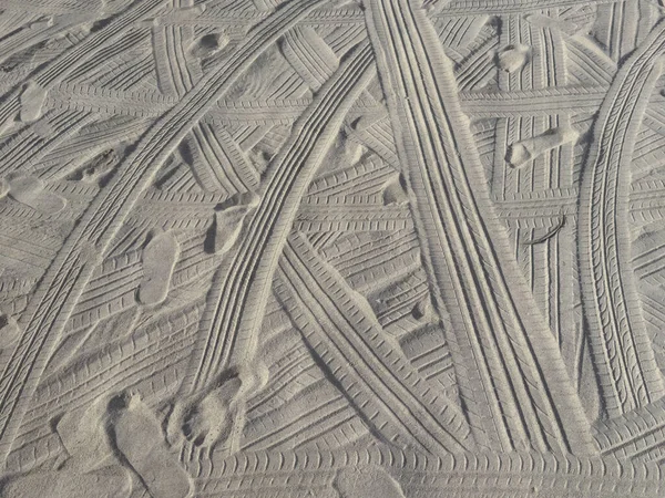 Background of tire tracks and foot prints on fine sand