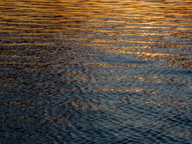 Gün batımında okyanus yüzeyindeki dalgaların arkaplanı 