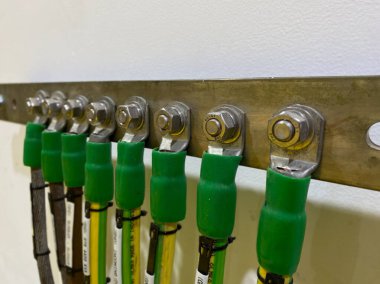 Topraklama sistemi için duvarda yüksek voltajlı bakır tel var. Elektriği topraklama sistemi. Kablo elektrik zemin çubuğuna bağlanıyor..